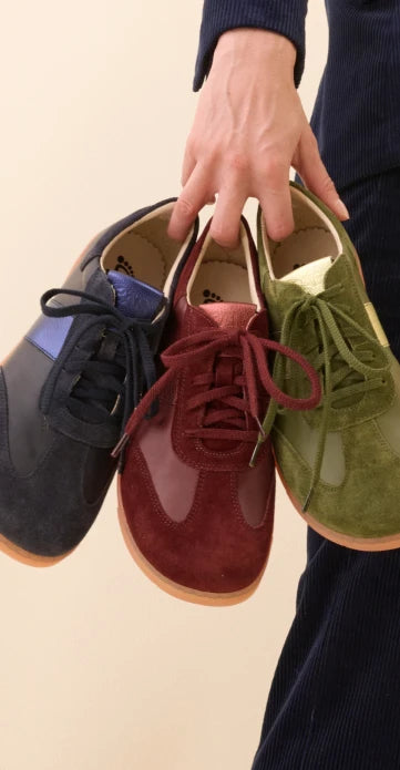 Frau hält Sneaker in der Hand
