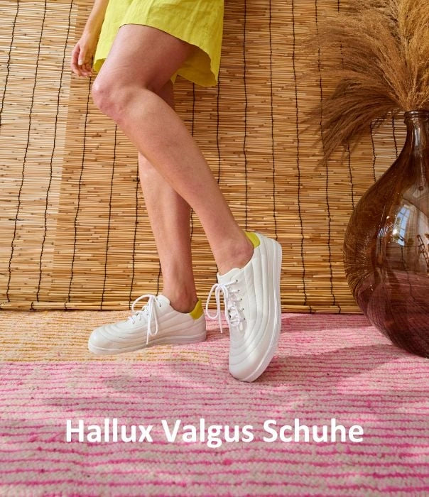 Frau trägt weiße Hallux Valgus Schuhe vor einer Bambuswand